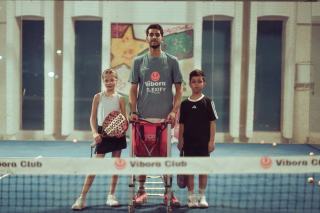 Joueur de padel qui se tient l'épaule après une frappe au-dessus de la tête